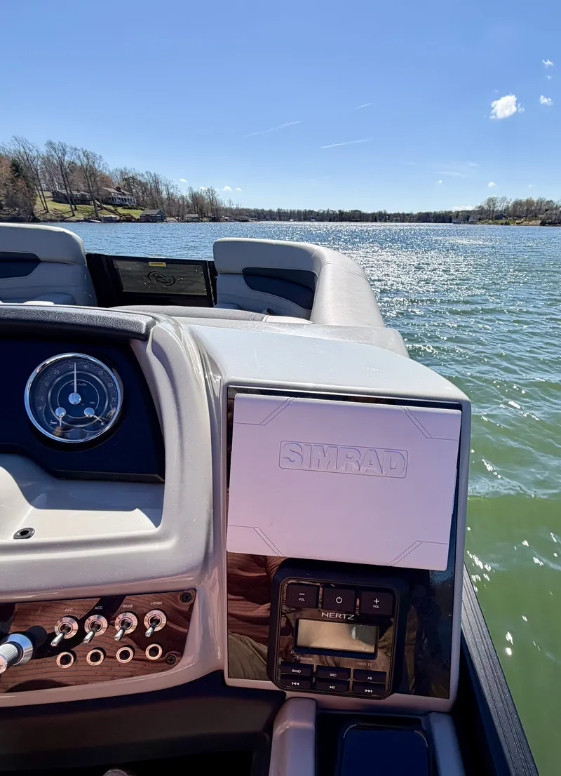 Slide: The Image of The image shows the cockpit of a 2024 Barletta Cabrio 24 UE on a lake. - 15