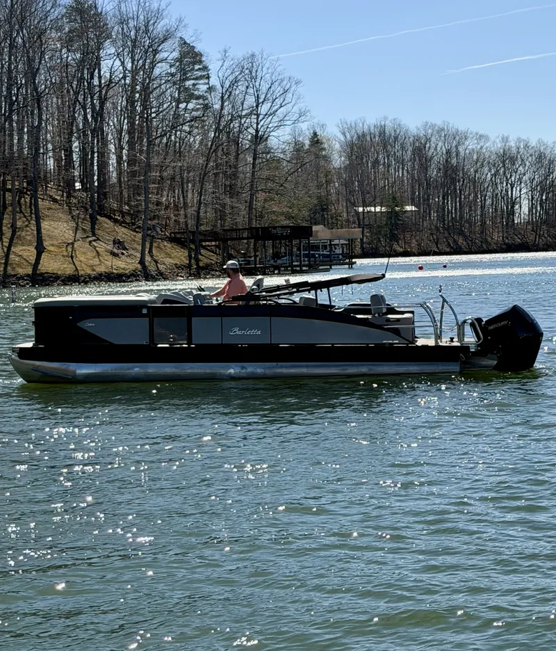Slide: The Image of A 2024 Barletta Cabrio 24 UE pontoon boat cruising on a calm lake. - 3