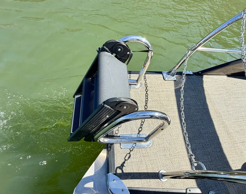 Slide: The Image of A stainless steel swim ladder on a boat floating on green water. - 9