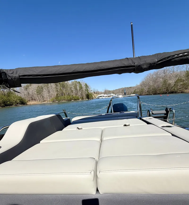Slide: The Image of The image shows the deck of a Barletta Cabrio 24 UE boat on a calm river. - 16