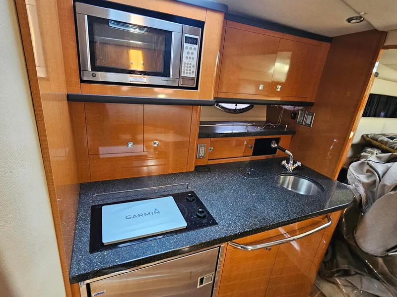 Slide: The Image of The 2011 Chaparral 370 Signature's galley features a microwave, sink, and countertop. - 4
