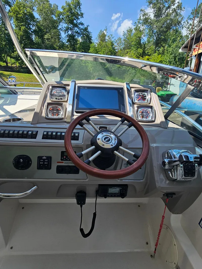 Slide: The Image of The image shows the helm of a 2011 Chaparral 370 Signature with a wooden steering wheel and modern instruments. - 7