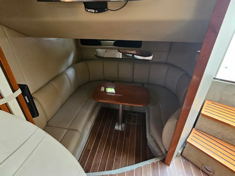 Slide: The Image of Interior of a 2011 Chaparral 370 Signature with cushioned seating and a wooden table. - 5