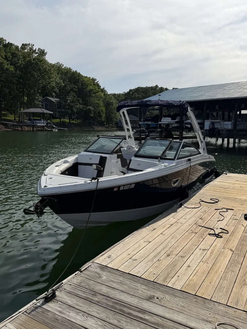 The Image of A sleek 2022 Cobalt R6 Outboard boat docked at a wooden pier on a calm lake. - 1