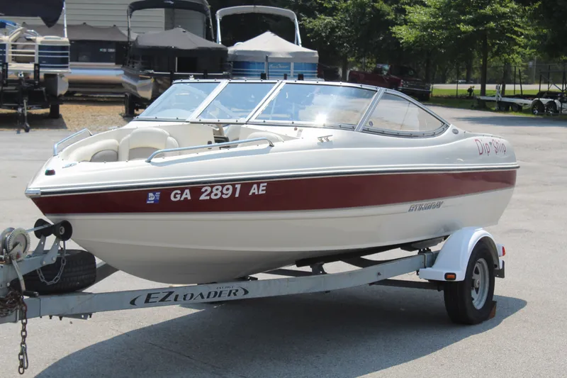 Slide: The Image of A white 2012 Stingray 185 LS boat on a trailer in an outdoor area. - 2
