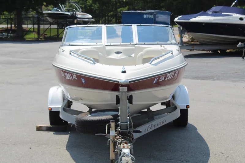 Slide: The Image of A white and red 2012 Stingray 185 LS boat is on a trailer in a parking lot. - 4