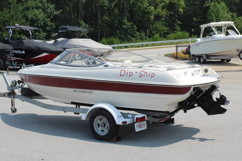 Slide: The Image of A white and red 2012 Stingray 185 LS boat on a trailer, parked in a lot. - 3
