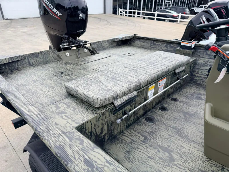 Slide: The Image of The image shows the deck of a Tracker Grizzly 2072 CC boat with a Mercury engine. - 13