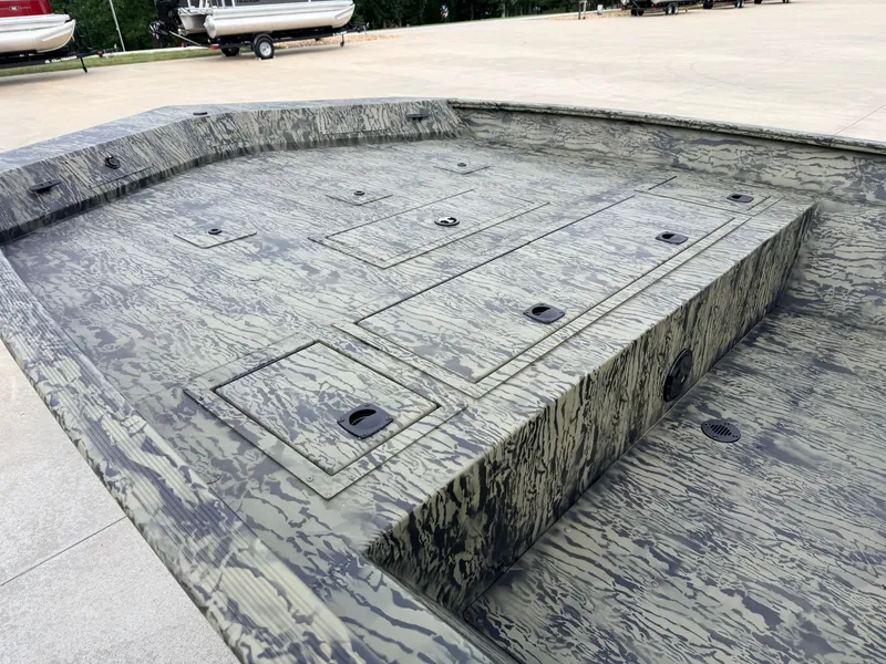 Slide: The Image of The image shows the deck of a Tracker Grizzly 2072 CC boat with a camouflage pattern. - 9