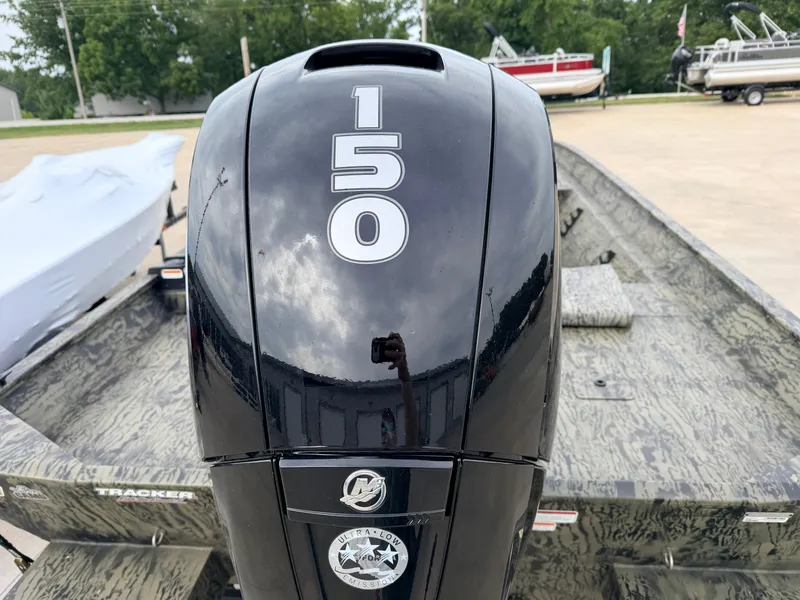 Slide: The Image of A Tracker Grizzly 2072 CC with a 150 HP outboard motor, parked on a concrete lot. - 5