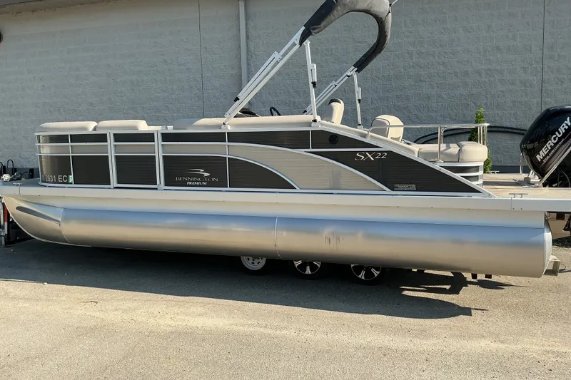 Slide: The Image of 2019 Bennington 22 SSLX pontoon boat with Mercury engine, parked outdoors. - 3