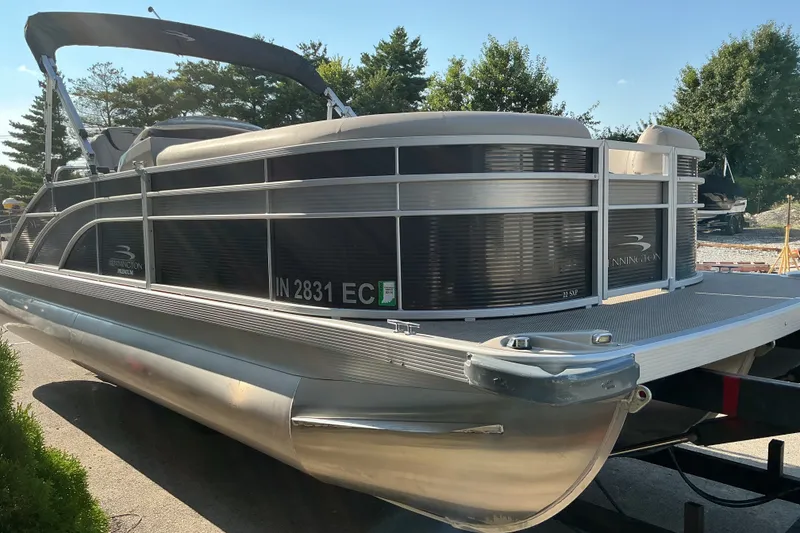 Slide: The Image of 2019 Bennington 22 SSLX pontoon boat parked outdoors, featuring sleek design and modern amenities. - 2