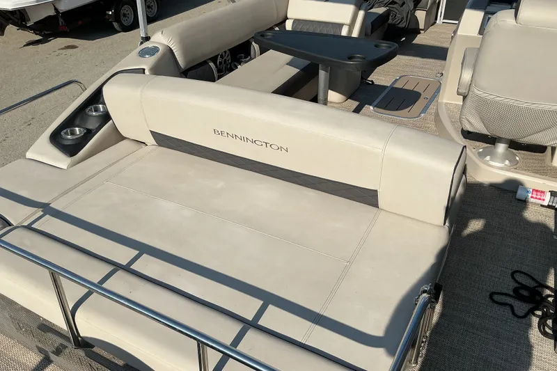 Slide: The Image of 2019 Bennington 22 SSLX pontoon boat with beige seating and cup holders. - 8