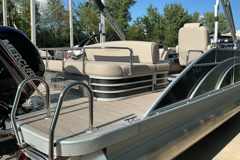 Slide: The Image of 2019 Bennington 22 SSLX pontoon boat with Mercury engine, docked outdoors. - 4
