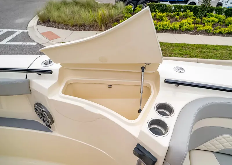 Slide: The Image of The image shows the storage compartment of a 2027 Scout 330 LXF boat with an open lid. - 34