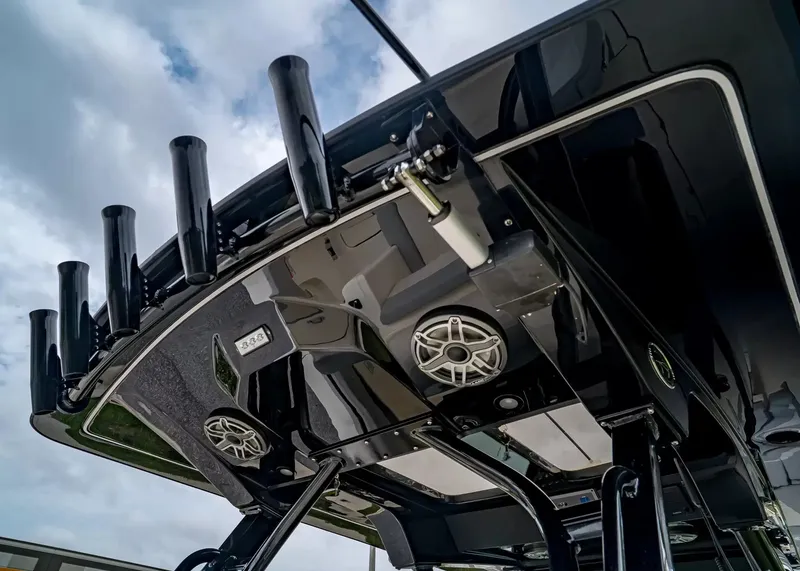 Slide: The Image of The image shows the roof of a Scout 330 LXF boat with speakers and fishing rod holders. - 18