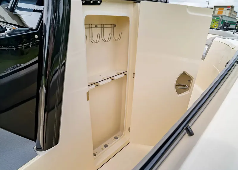 Slide: The Image of An open storage compartment with hooks and holders on a Scout 330 LXF boat. - 25