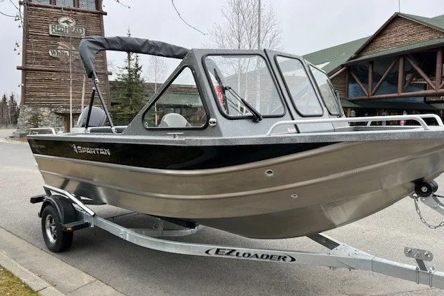 Slide: The Image of 2024 Spartan 185 Astoria boat on EZ Loader trailer, parked outdoors. - 1
