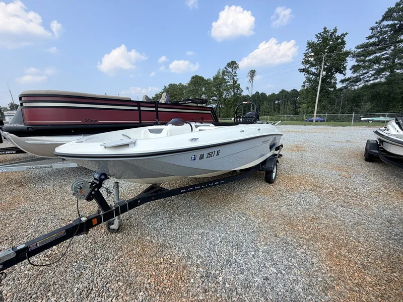 Slide: The Image of A white 2018 Bayliner 180 Element XL boat on a trailer in a gravel lot. - 19