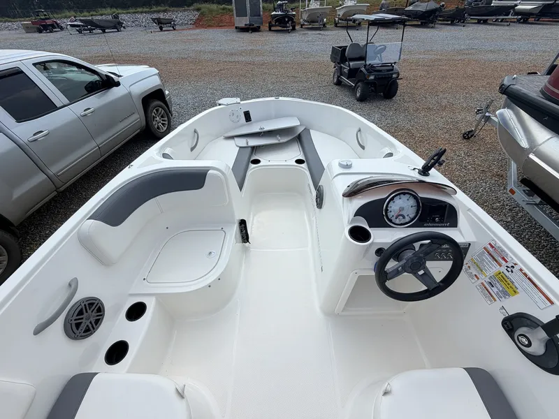 Slide: The Image of The image shows the cockpit of a 2018 Bayliner 180 Element XL. It features white seating and a simple dashboard. - 13