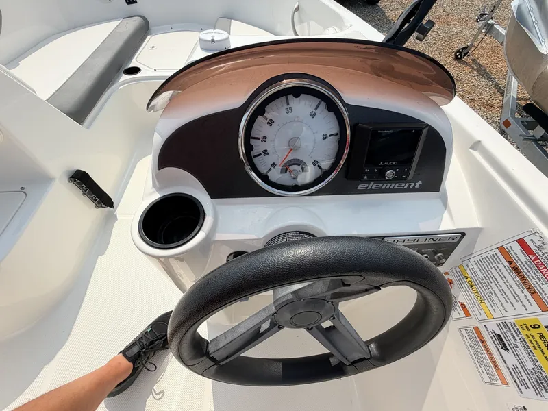 Slide: The Image of The image shows the cockpit of a 2018 Bayliner 180 Element XL with a steering wheel and instruments. - 16