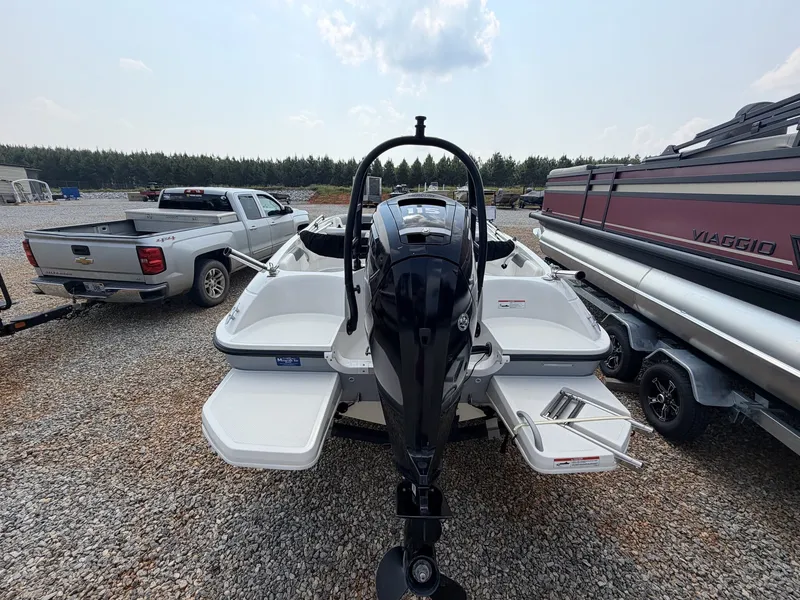 Slide: The Image of A 2018 Bayliner 180 Element XL on a gravel lot. An engine is visible at the rear. - 15