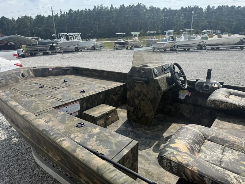 Slide: The Image of The image shows a 2027 Lowe Roughneck 1650SC boat with camouflage pattern, parked on a gravel lot. - 6
