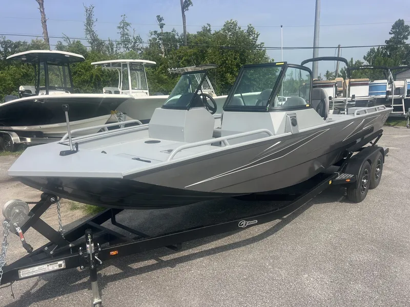 Slide: The Image of A gray 2027 G3 Sportsman 2100-CATFISH boat sits on a trailer in a parking lot. - 1