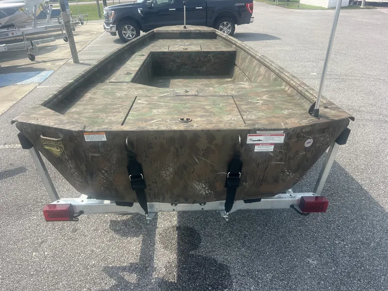 Slide: The Image of A G3 Gator Tough 15DK boat with camouflage pattern, parked on a trailer. - 6