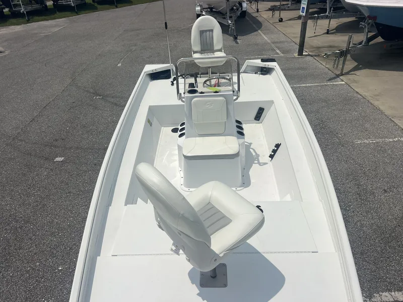 Slide: The Image of A modern white boat with two cushioned seats and a helm, situated in a parking area. - 4