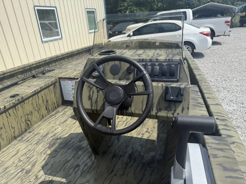 Slide: The Image of The image shows the cockpit of a Lowe Roughneck 1650SC boat with a steering wheel and console. - 2