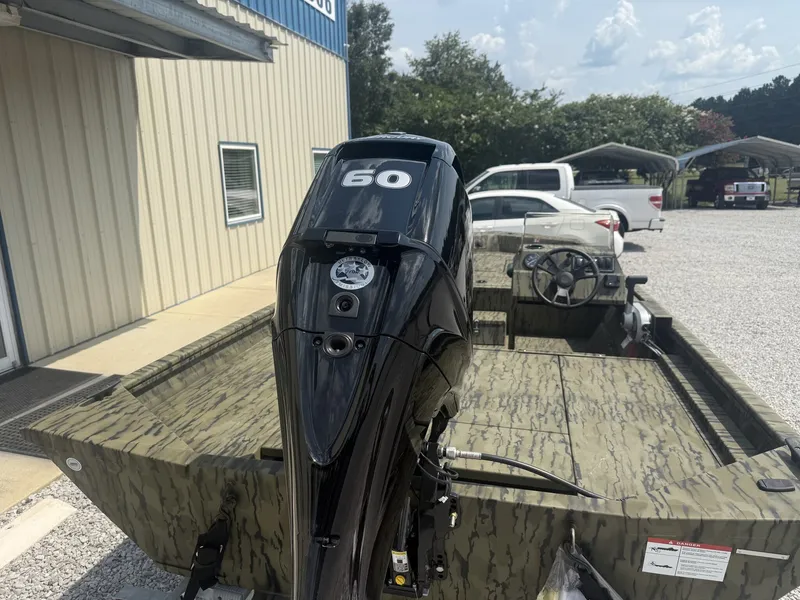 Slide: The Image of A Lowe Roughneck 1650SC boat with a 60 HP motor, parked on a gravel lot. - 4