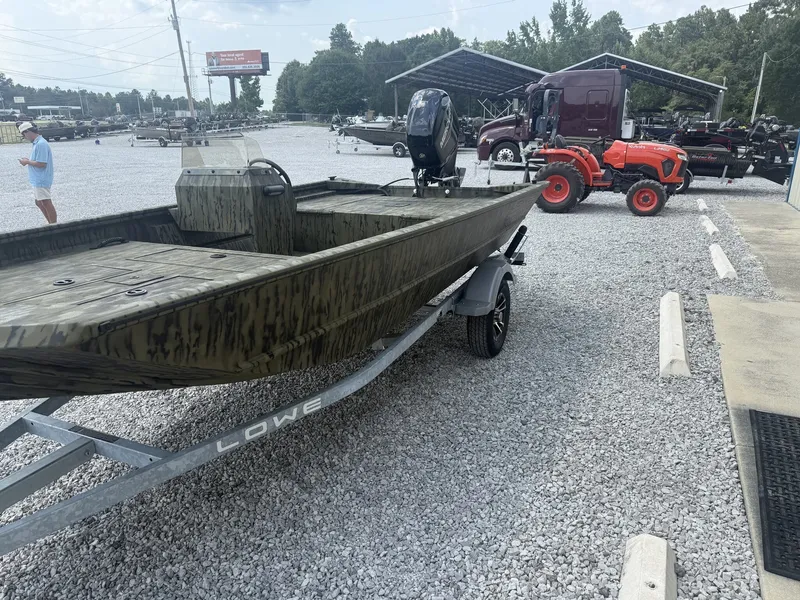 Slide: The Image of A Lowe Roughneck 1650SC boat on a trailer, surrounded by gravel and vehicles. - 3