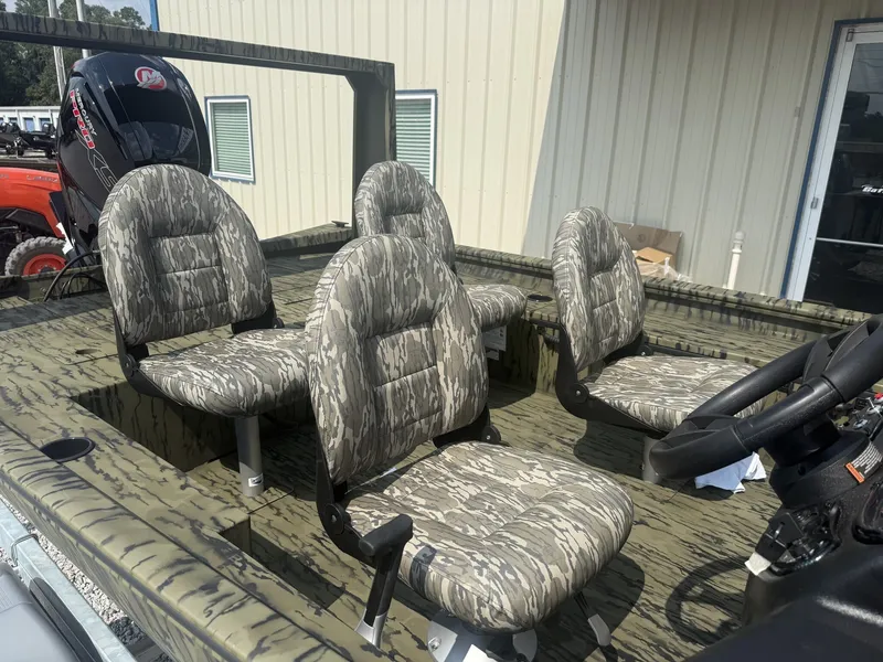 Slide: The Image of Four padded seats in a camouflage-patterned boat, parked next to a building. - 6