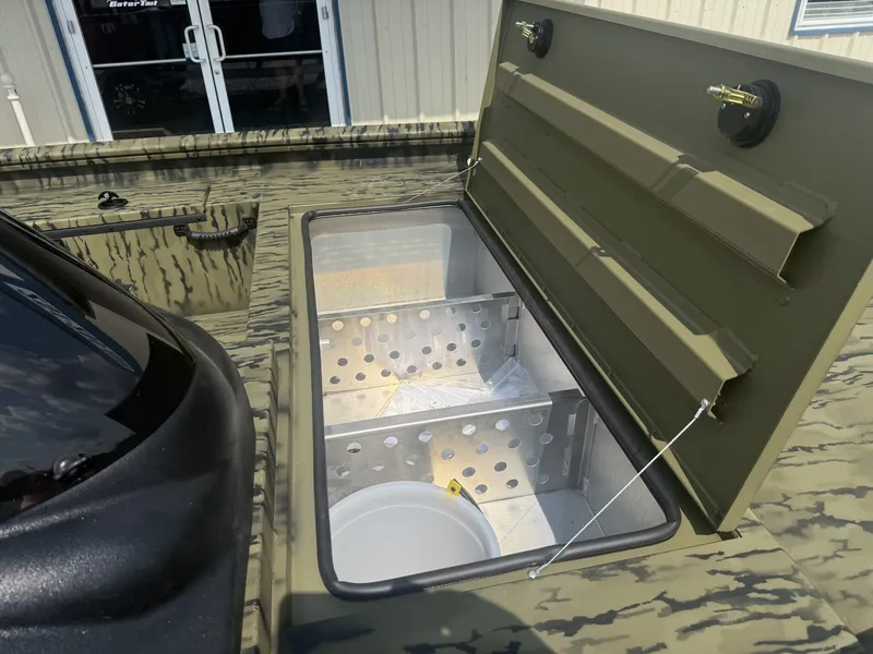 Slide: The Image of An open storage compartment on a Lowe Outlet 20-CATFISH boat, featuring perforated metal dividers. - 2