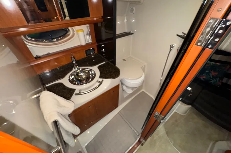 Slide: The Image of 2006 Four Winns 348 Vista yacht bathroom with sink, toilet, and wooden cabinetry. - 10