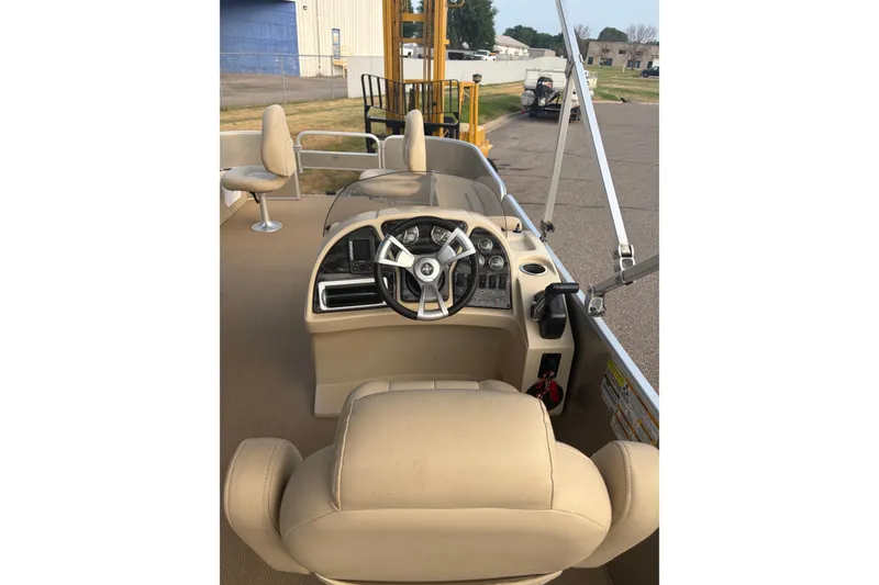 Slide: The Image of 2015 Sweetwater 2286 boat interior with beige seating and steering console. - 19