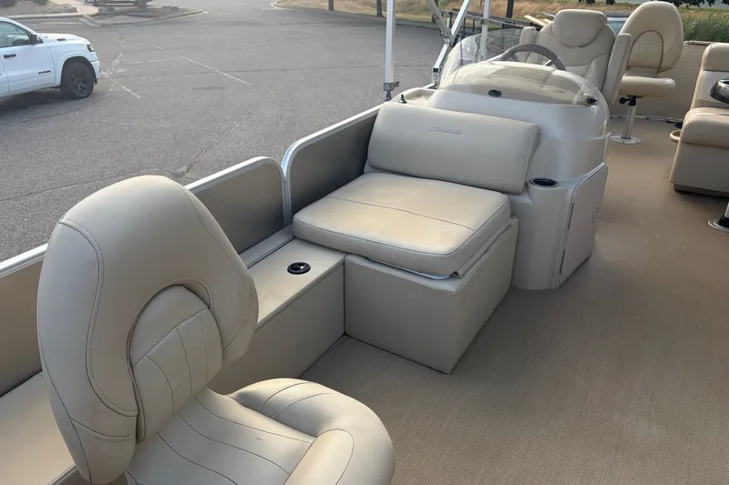 Slide: The Image of 2015 Sweetwater 2286 boat interior with beige seating and steering console. - 11
