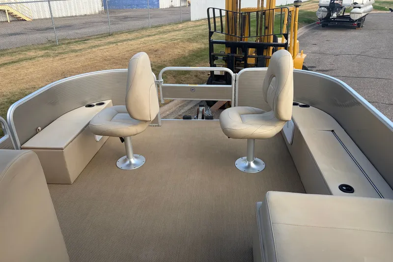 Slide: The Image of 2015 Sweetwater 2286 pontoon boat interior with beige seating and carpeted deck. - 10