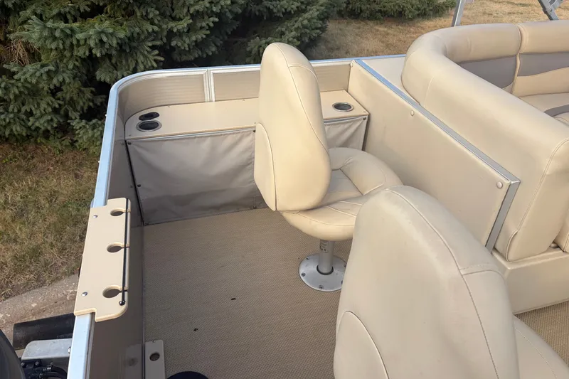 Slide: The Image of 2015 Sweetwater 2286 boat interior with beige seating and cup holders. - 14