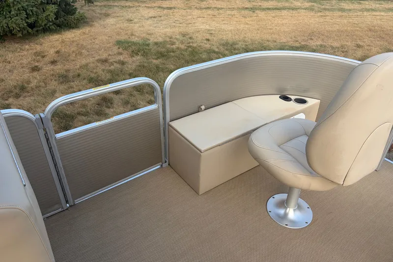 Slide: The Image of 2015 Sweetwater 2286 pontoon boat interior with beige seating and storage. - 13