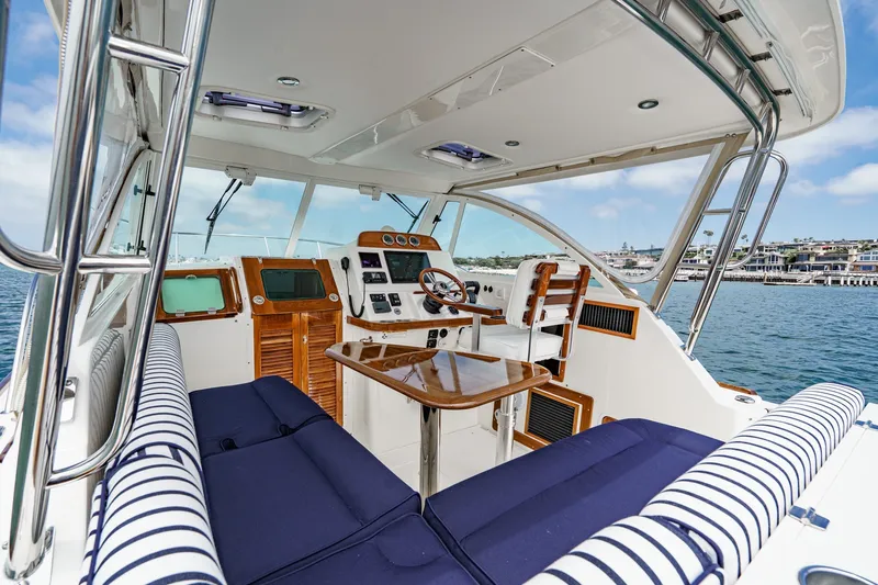 Slide: The Image of 2020 Hunt Yachts Surfhunter 32 interior with striped seating, wooden accents, and ocean view. - 32