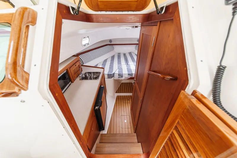 Slide: The Image of Interior of 2020 Hunt Yachts Surfhunter 32, featuring wood finishes and compact kitchenette. - 46
