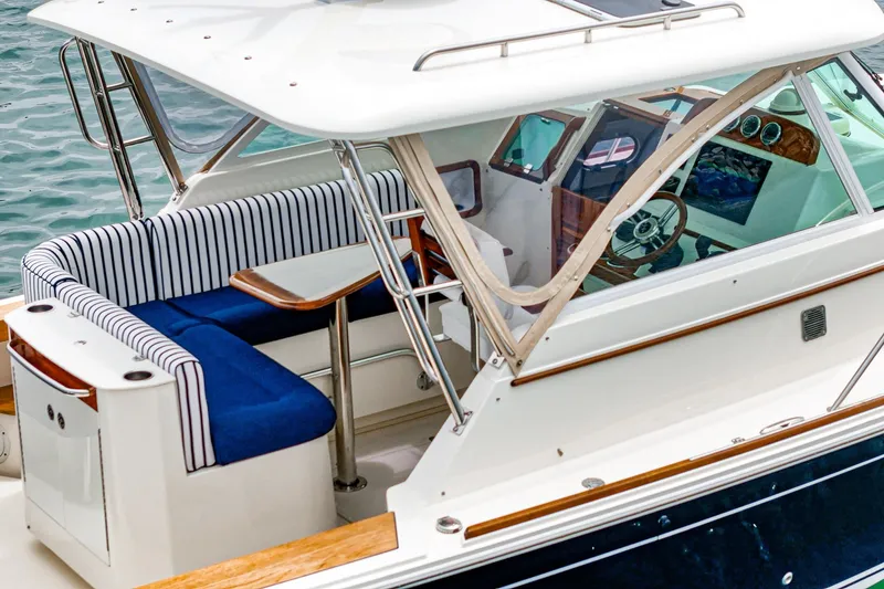 Slide: The Image of 2020 Hunt Yachts Surfhunter 32 with striped seating and elegant helm, docked on water. - 28