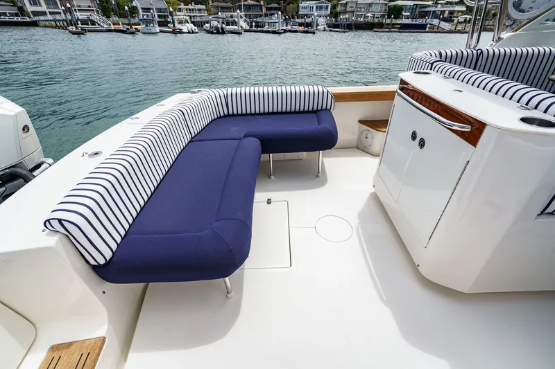 Slide: The Image of 2020 Hunt Yachts Surfhunter 32 with striped seating, docked in a marina. - 20