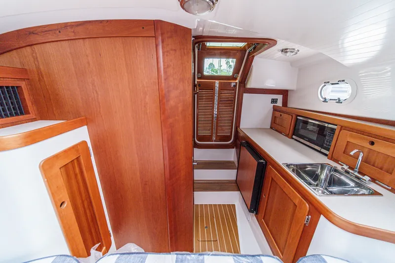 Slide: The Image of Interior of 2020 Hunt Yachts Surfhunter 32, featuring wood cabinetry and compact kitchen area. - 54
