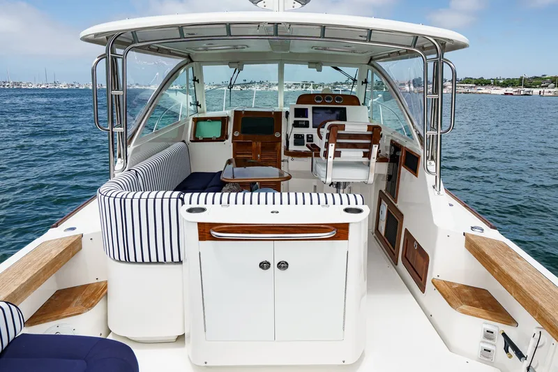 Slide: The Image of 2020 Hunt Yachts Surfhunter 32 interior with striped seating, helm, and ocean view. - 24