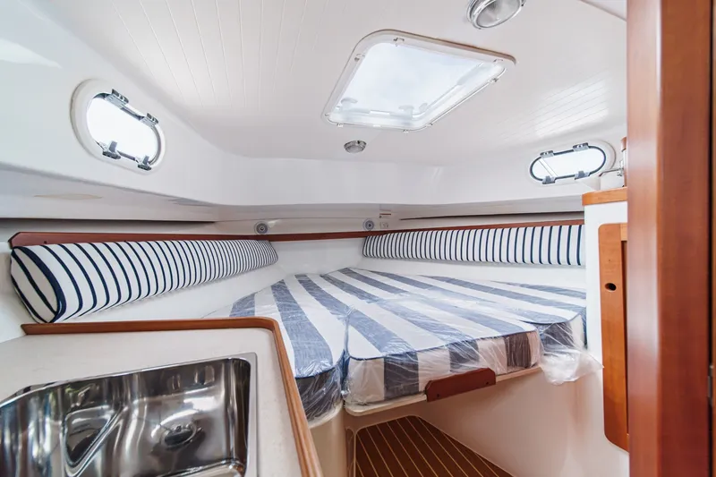 Slide: The Image of 2020 Hunt Yachts Surfhunter 32 cabin interior with striped bedding and portholes. - 52