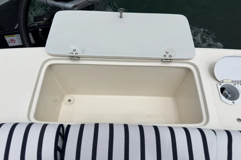 Slide: The Image of Open storage compartment on 2020 Hunt Yachts Surfhunter 32 boat with striped seating. - 21