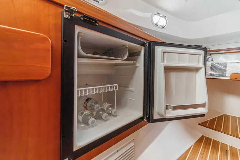 Slide: The Image of Compact refrigerator inside 2020 Hunt Yachts Surfhunter 32, stocked with bottled water. - 50